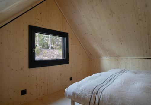 a bed in a room with a window at Majamaja Helsinki off-grid retreat in Helsinki