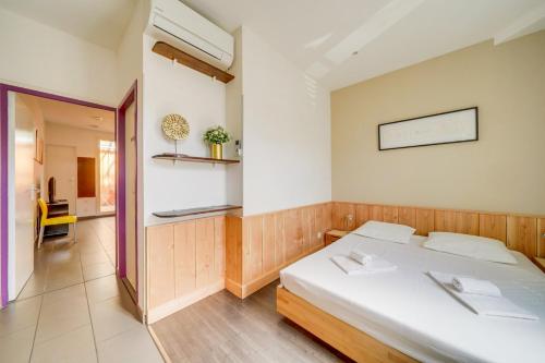 - une chambre avec un lit blanc dans l'établissement Jolie petite maison de ville Bordeaux, à Bordeaux