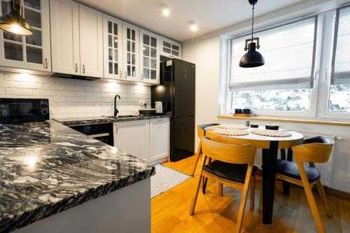 a kitchen with white cabinets and a table and chairs at Na Bogówce in Zakopane