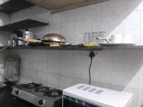 Il comprend une cuisine équipée d'une cuisinière et d'un comptoir. dans l'établissement A rustic earthy home A1, à Mumbai