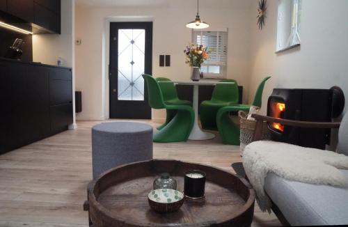 a living room with green chairs and a table at Bokrijklodge in Hasselt