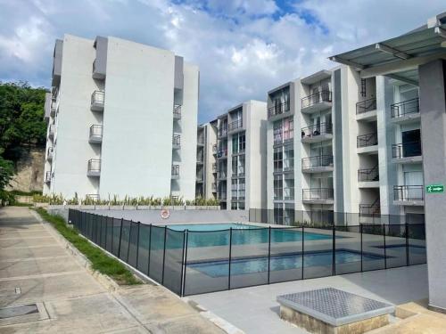 een appartementencomplex met een zwembad ervoor bij Apto amoblado Melgar con Piscina in Melgar