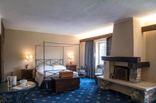 a hotel room with a bed and a fireplace at La Meridiana ReIais & Chateaux in Garlenda