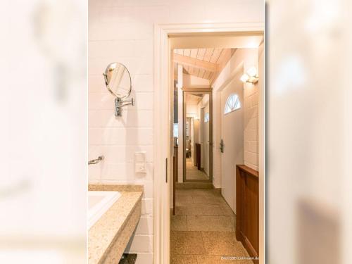W łazience znajduje się umywalka i lustro. w obiekcie Strandhaus Fischer w Prerowie