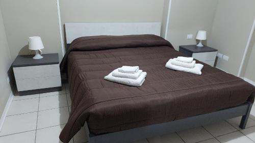 1 dormitorio con 1 cama con 2 toallas en b&b Sirianni, en SantʼEufemia Lamezia