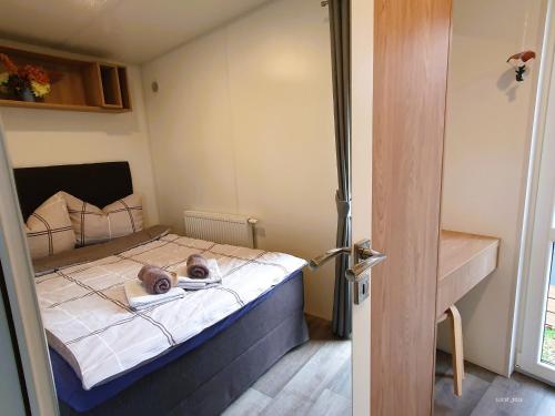 a small bed in a small room with a door at Tinyhaus im Altmühltal in Beilngries
