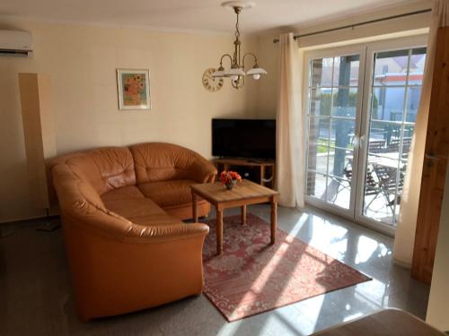 ボルテンハーゲンにあるHaus-Koralle-Wohnung-rechtsのリビングルーム(茶色の革張りのソファ、テーブル付)