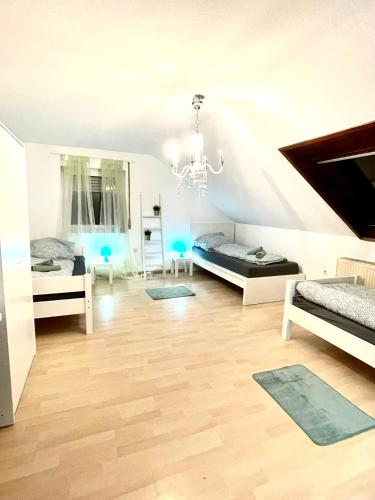 ein Wohnzimmer mit 2 Betten und einem Kronleuchter in der Unterkunft Ferienwohnung für 5 Personen, gemütlich und möbliert in Stein bei Nürnberg