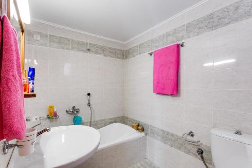 a bathroom with a white sink and a pink towel at Eden Beach Hotel in Agia Marina Nea Kydonias