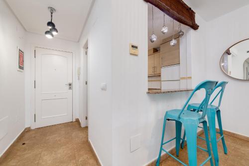 a hallway with two blue chairs in a room at Mi Patio in Torrevieja