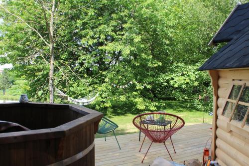 d'un patio avec un hamac et des chaises sur une terrasse. dans l'établissement Cabane dans un jardin arboré, à LʼAbsie