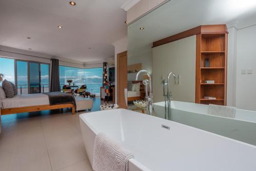 Sea Star Lodge في غانسباي: حمام به سرير وحوض استحمام وغرفة نوم