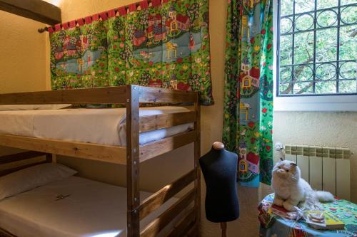 a bedroom with bunk beds and a cat sitting on a table at La Meridiana ReIais & Chateaux in Garlenda
