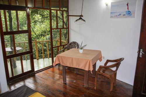 una mesa y sillas en una habitación con balcón en Seasons Four Eco Friendly Treehouse en Matara