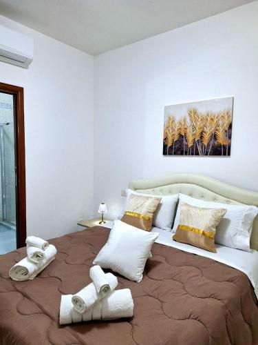 una camera da letto con un letto grande con asciugamani sopra di Black & White a Cagliari