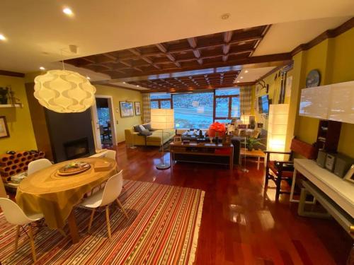 a living room with a table and chairs and a living room at Vistas del Toneo in Puebla de Lillo
