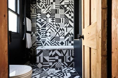 a bathroom with a black and white patterned wall at Stylish flat central Brighton in Brighton & Hove