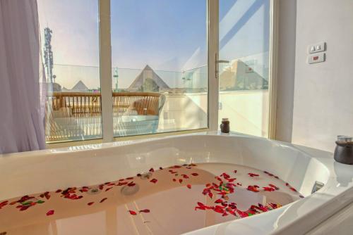 a bath tub filled with red flower petals at Tree Lounge Pyramids View INN , Sphinx Giza in Cairo