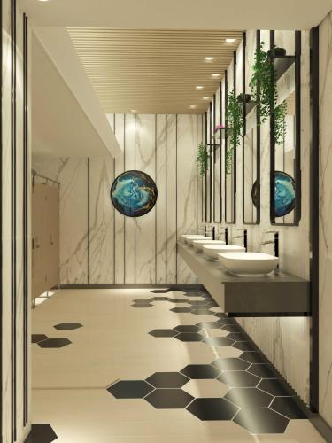 a bathroom with three sinks and two wash basins at Hyatt Place Makassar in Makassar
