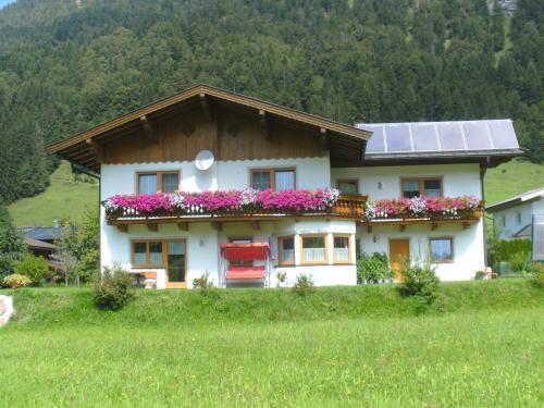 a house with a solar roof with flowers on it at Ferienwohnung Biechl-Hauser Doris in Sankt Ulrich am Pillersee