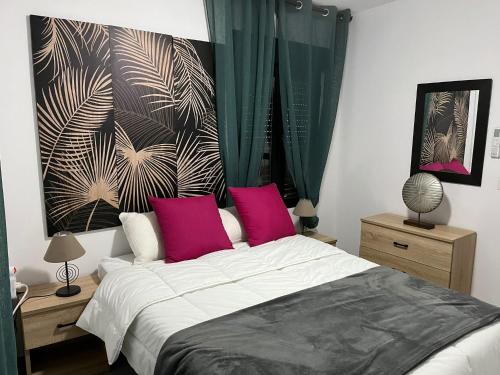 1 dormitorio con 1 cama grande con almohadas rosas en Sunny Holiday Terrace Apartment, en Almuñécar
