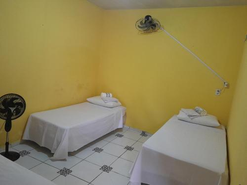 een kamer met 2 bedden en een lampje aan de muur bij Família nunes in Barreirinhas
