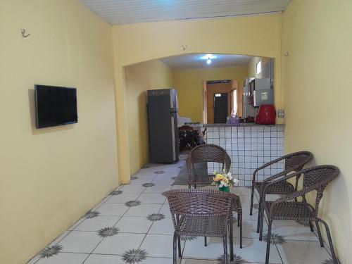 een kamer met stoelen en een keuken met een koelkast bij Família nunes in Barreirinhas