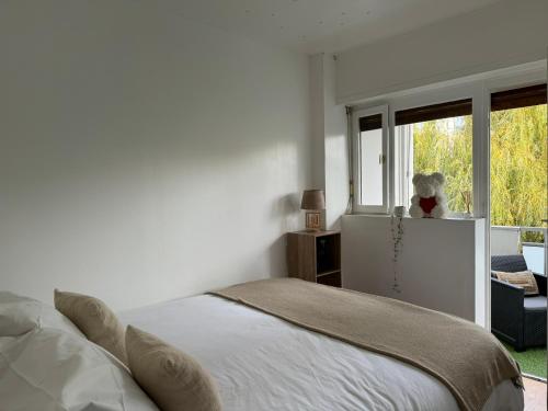 um quarto branco com uma cama e uma janela em La perle em Annecy