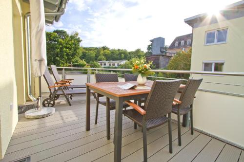 eine Terrasse mit Tisch und Stühlen auf einem Balkon in der Unterkunft Domizil am Hang, App. A04 in Heringsdorf