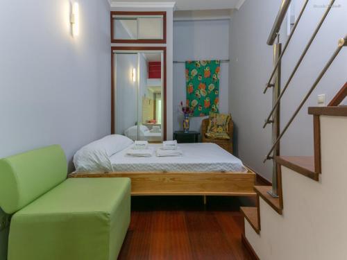 Habitación pequeña con cama y sofá verde en B28 - Stylish Typical House, en Lagos