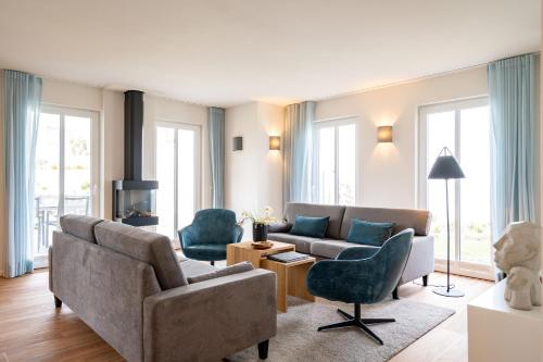ein Wohnzimmer mit Couch und Sesseln in der Unterkunft Domizil Meerzeit, App. 7 in Ahlbeck