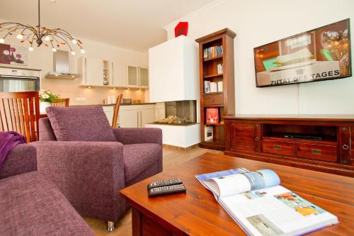 ein Wohnzimmer mit einem Sofa und einem Tisch in der Unterkunft Dünenpalais, App. 06 in Ahlbeck