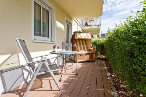 eine Terrasse mit einem Tisch und Stühlen auf dem Balkon in der Unterkunft Dünenpalais, App. 06 in Ahlbeck