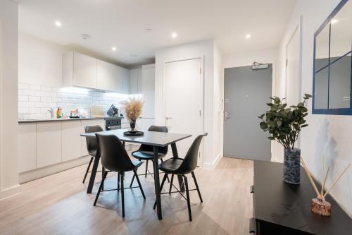 a kitchen and dining room with a table and chairs at Morden 2 Bed Apartment - Manchester Old Trafford in Manchester