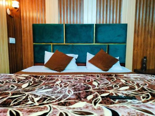 a bedroom with a large bed with a blue headboard at Kanha hotel in Shimla