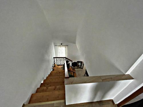 een trap met een witte muur en een raam bij Cabana Bilbor in Bilbor