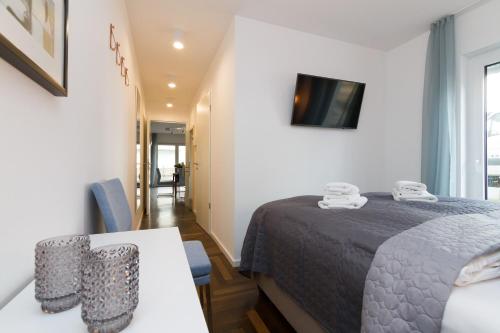 a bedroom with a bed and a table and a television at Duenenresidenz Heringsdorf App 01 in Bansin