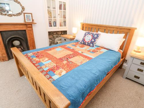 a bedroom with a bed with a quilt on it at Dolphin Cottage in Falmouth
