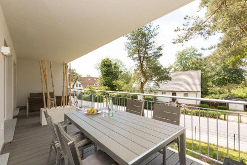 um deque com uma mesa de madeira e cadeiras numa varanda em Duenenresidenz Heringsdorf App 09 em Bansin