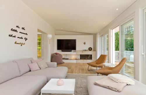 een woonkamer met een witte bank en een open haard bij Ferienhaus Adlerhorst in Bansin