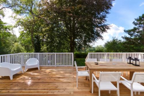 een houten terras met witte stoelen en een houten tafel bij Ferienhaus Adlerhorst in Bansin