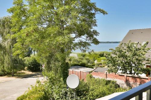 un balcón con un árbol y vistas al agua en Ferienhaus Hygge Hus, en Sellin