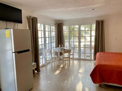 um quarto com um frigorífico e uma mesa com cadeiras em Skyline Suite em Playa del Carmen