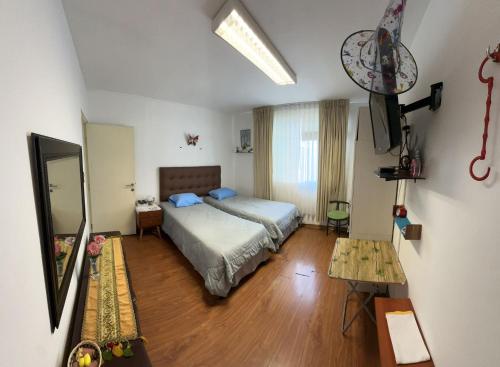 Un dormitorio con una cama y una mesa. en Teté, en Lima
