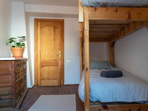 a bedroom with a bunk bed and a wooden door at Casa Canela in Órgiva