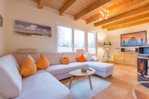 ein Wohnzimmer mit einer weißen Couch und einem Tisch in der Unterkunft Ferienhaus Silva in Ostseebad Koserow