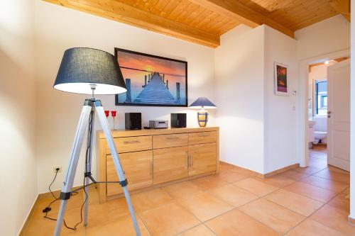 a tripod in a room with a lamp and a tv at Ferienhaus Silva in Ostseebad Koserow