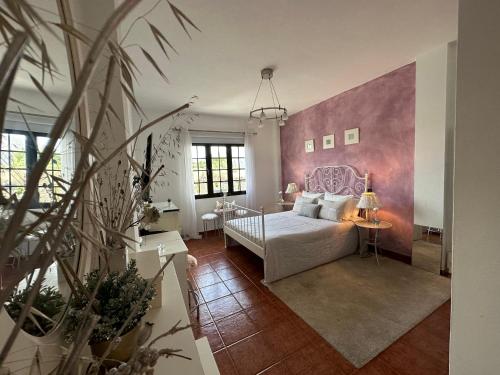 um quarto com uma cama e uma parede rosa em Habitación Dache Lanzarote em Tías