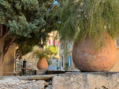 two large vases sitting on top of a stone wall at Studio Liège, vue mer au village de Bormes les Mimosas in Bormes-les-Mimosas