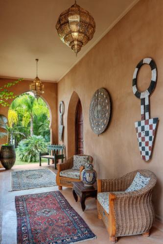 a living room with two chairs and a couch at Palais Hassoun Marrakech in Oulad Snaguia